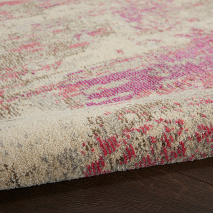 Beige plush area rug with pink abstract pattern; tufted pile and visible edge on dark wood floor, contemporary style.