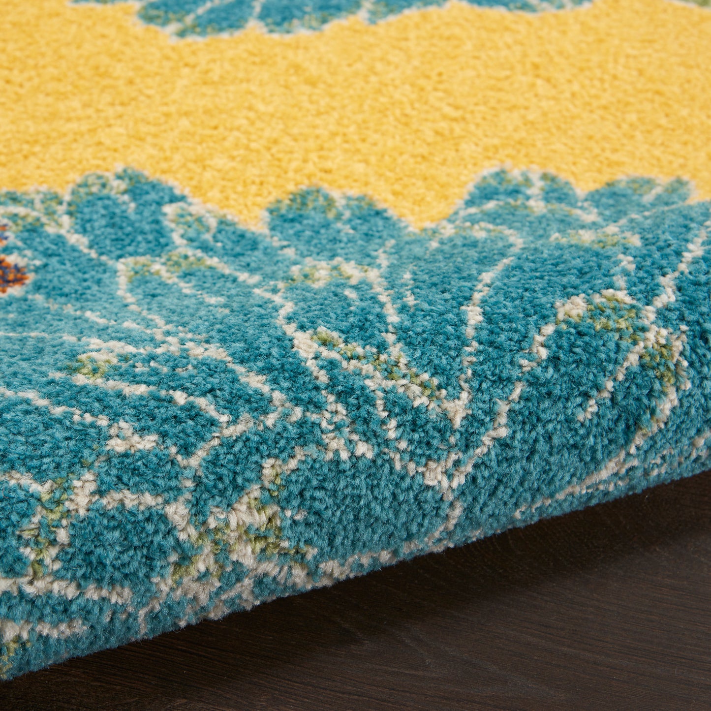 Close-up of a blue and yellow shaggy area rug with thick pile and abstract pattern.
