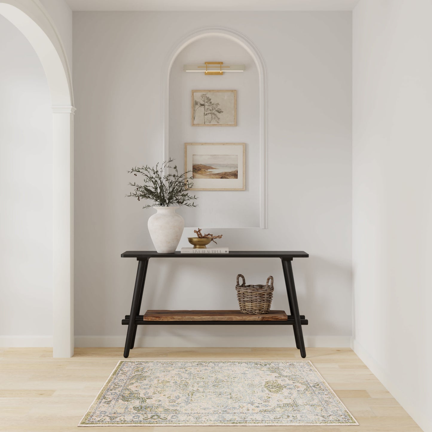 Black two-tier console table in an arched alcove with vase, greenery, wicker basket, framed art, and a neutral rug.