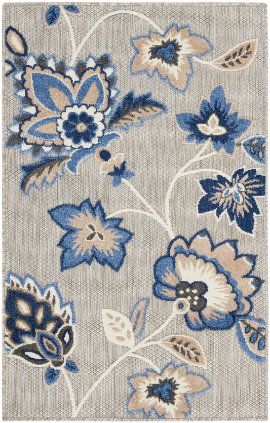 Rectangular woven rug featuring bold blue and tan floral pattern on a light beige background.