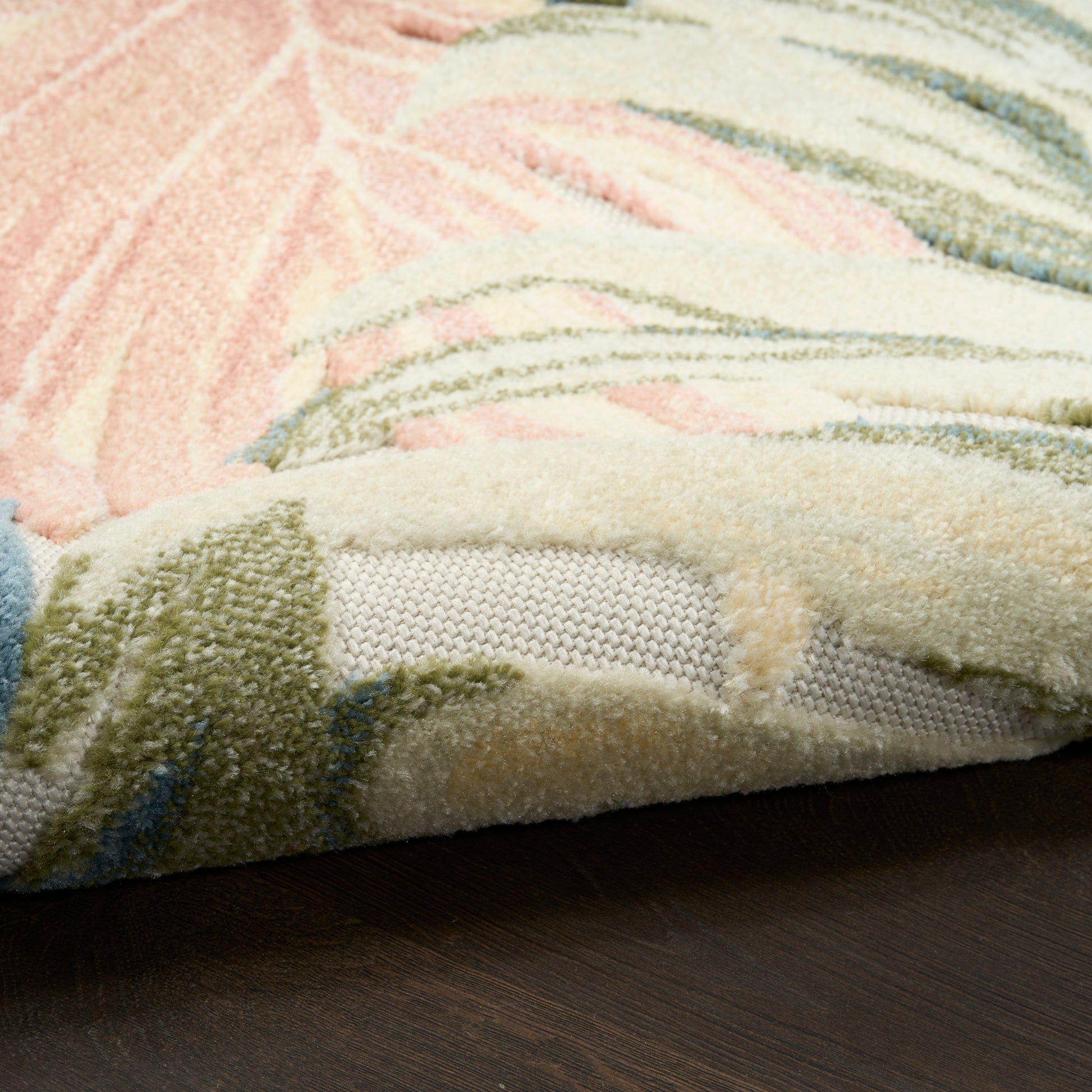 Pastel shag rug with pink, cream, green and blue tones; fluffy texture, abstract pattern, soft living-room flooring.