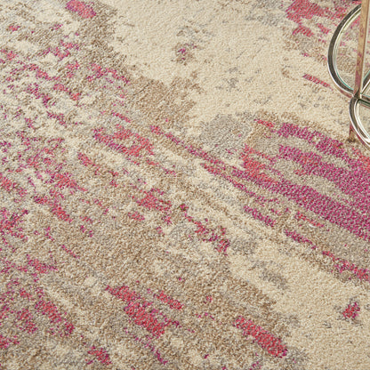 Beige rug with pink abstract floral pattern and soft, textured pile; metal chair leg visible at edge.