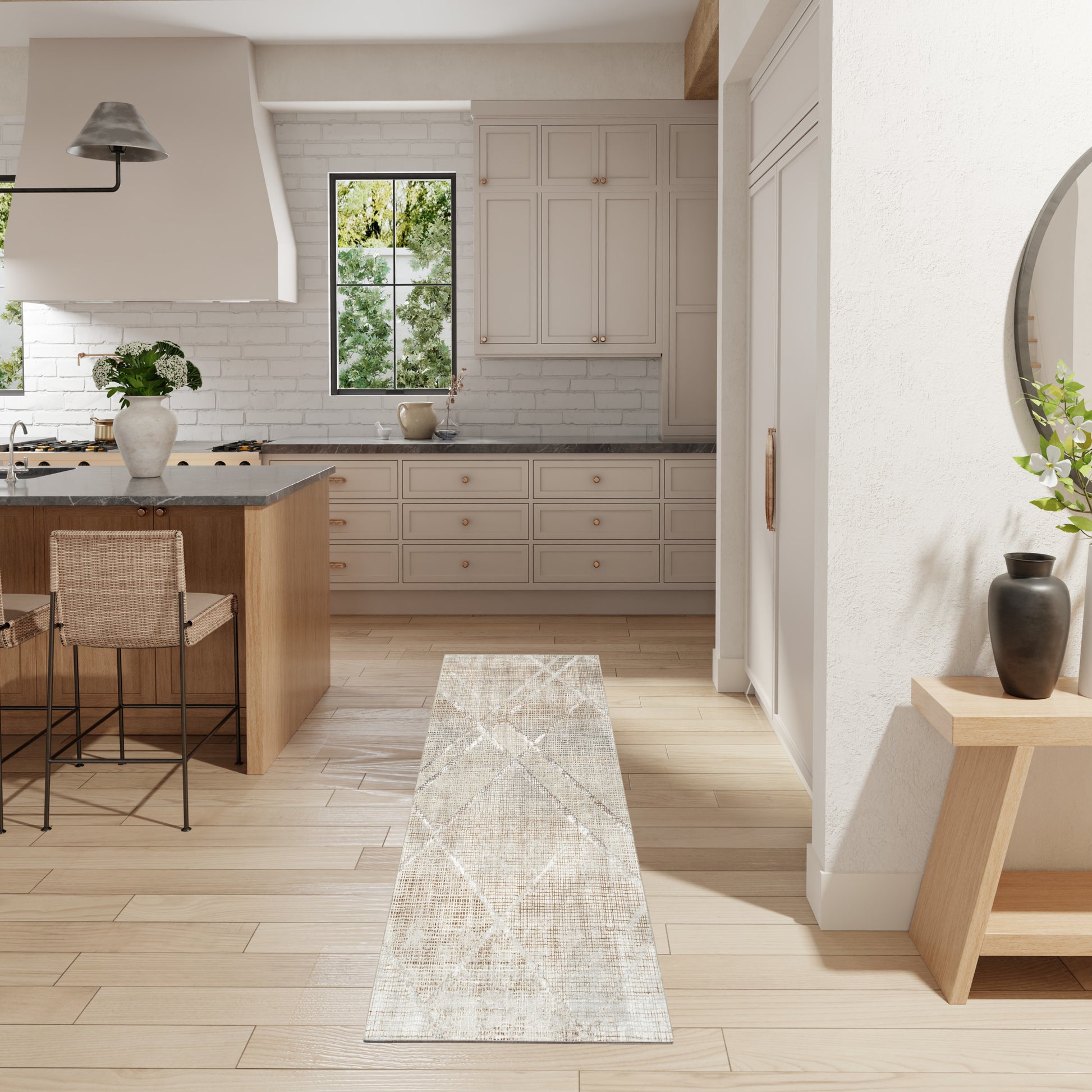 Bright modern kitchen with white cabinets, light wood floor, island with wicker stools, window view, beige runner rug