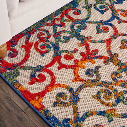 Colorful ornate patterned rug with red, blue, green and orange scrollwork on beige background; blue edge trim.