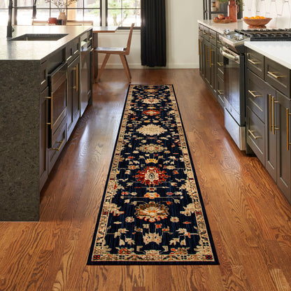 Long navy floral Persian-style runner rug on hardwood floor between dark gray cabinets with gold hardware, island & stove.