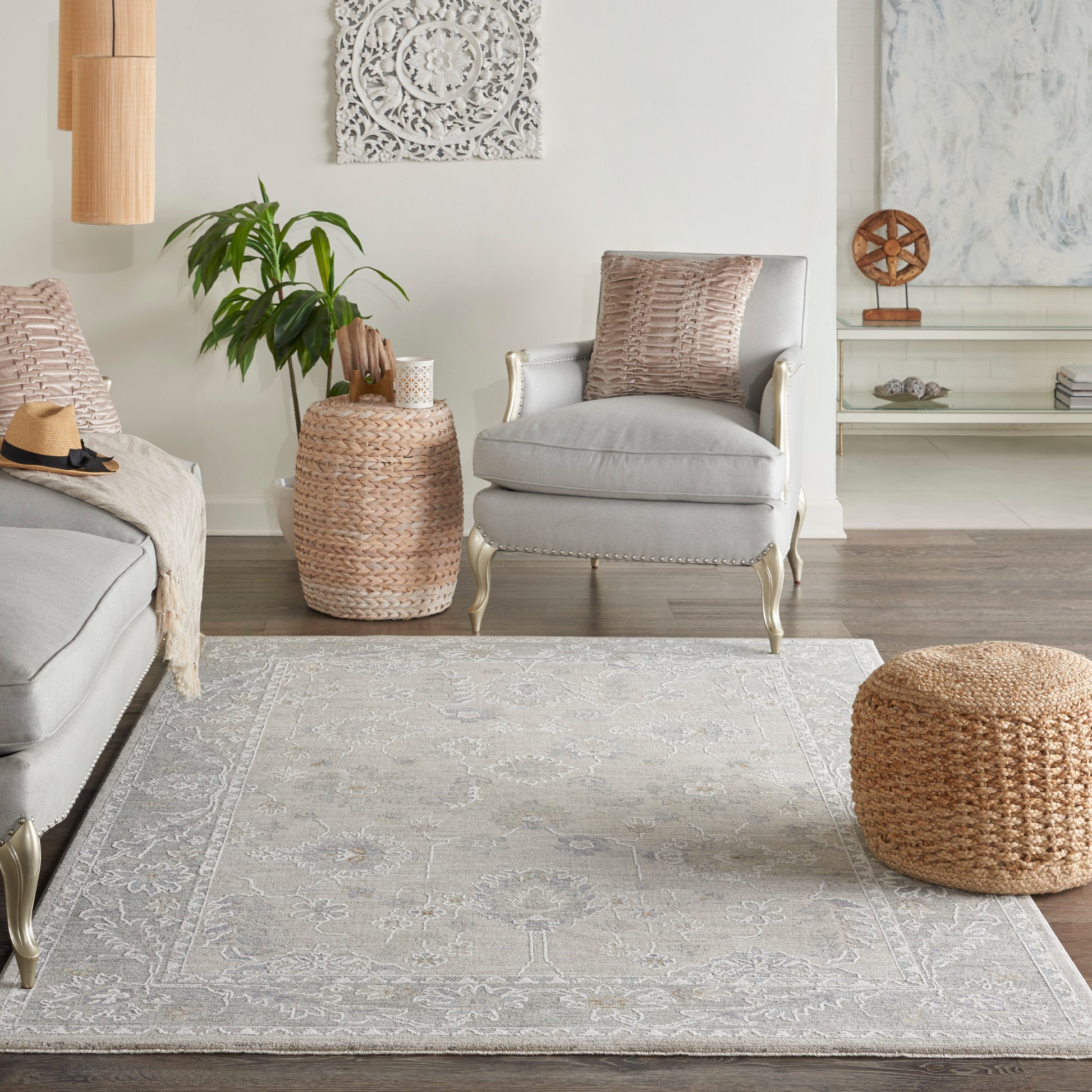 Vintage patterned rug (5' x 8') in a boho living room with a light gray armchair, woven rattan pouf, and natural wicker side table.
