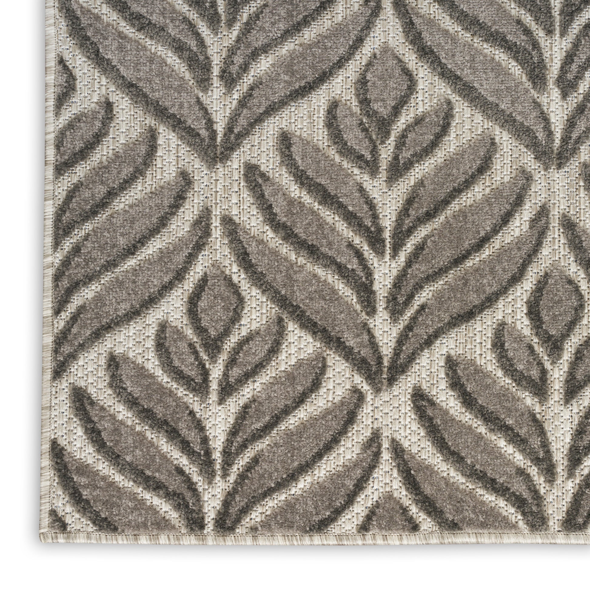 Beige and taupe woven rug with large raised leaf pattern and textured pile.