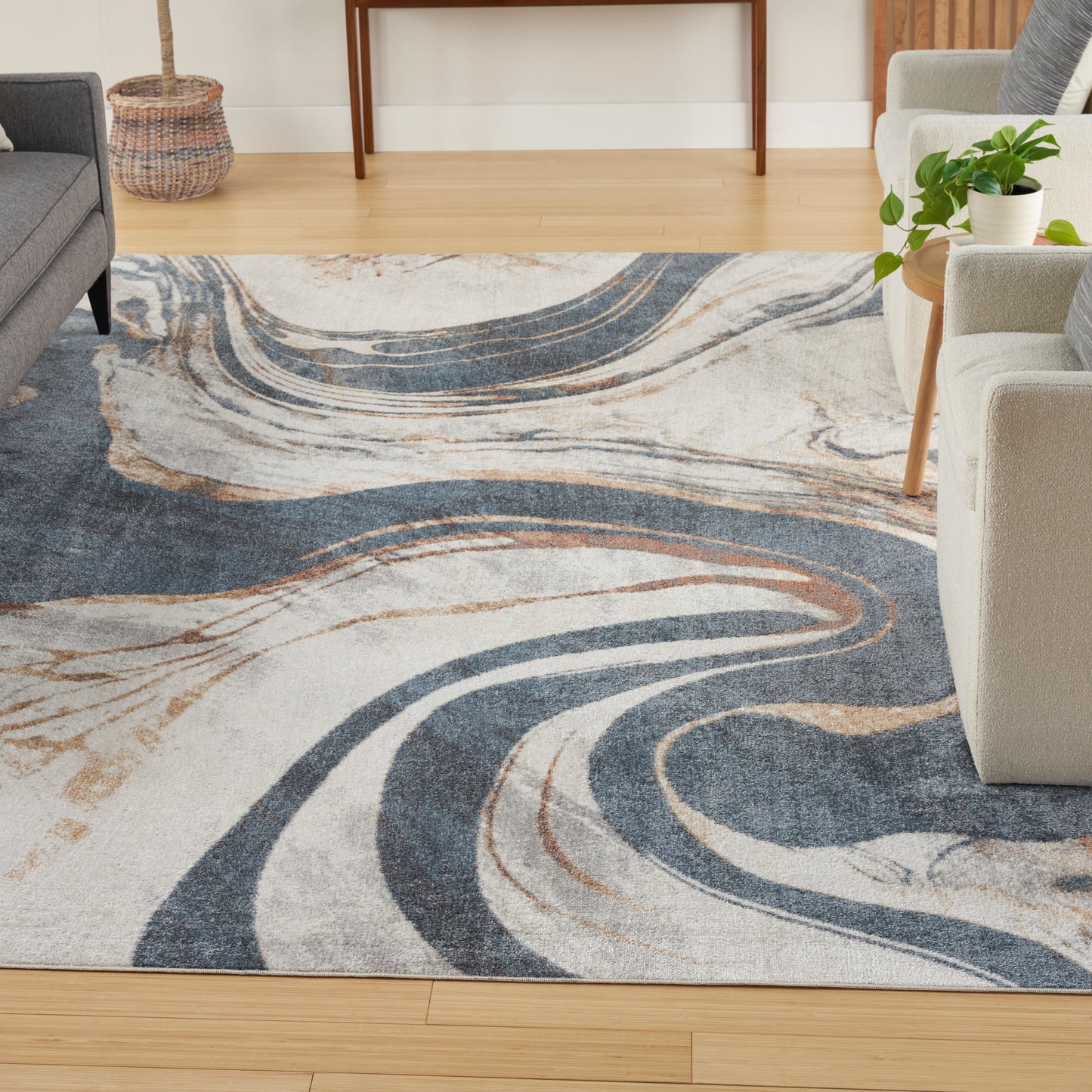 Rectangular plush area rug with swirling navy, beige and cream patterns in a contemporary living room.