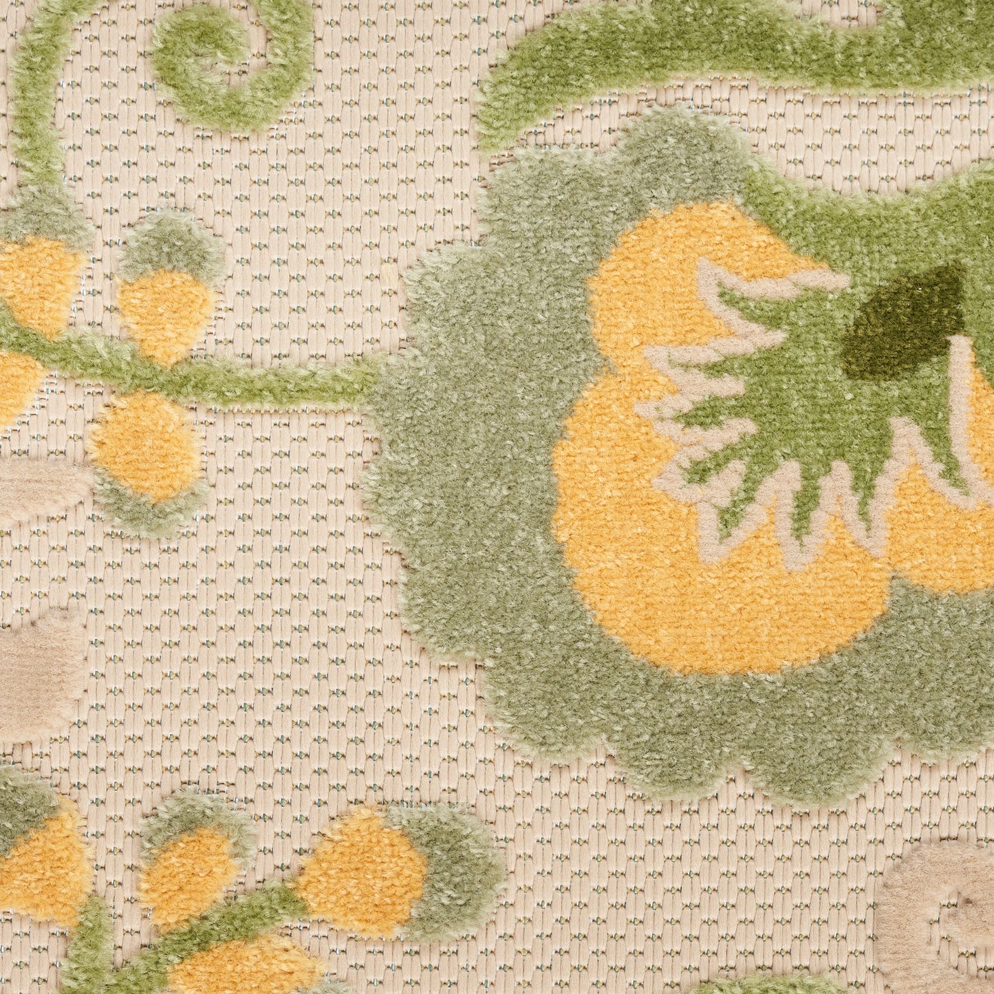Close-up of a tufted beige floral rug with large yellow-orange petals and green leaves.