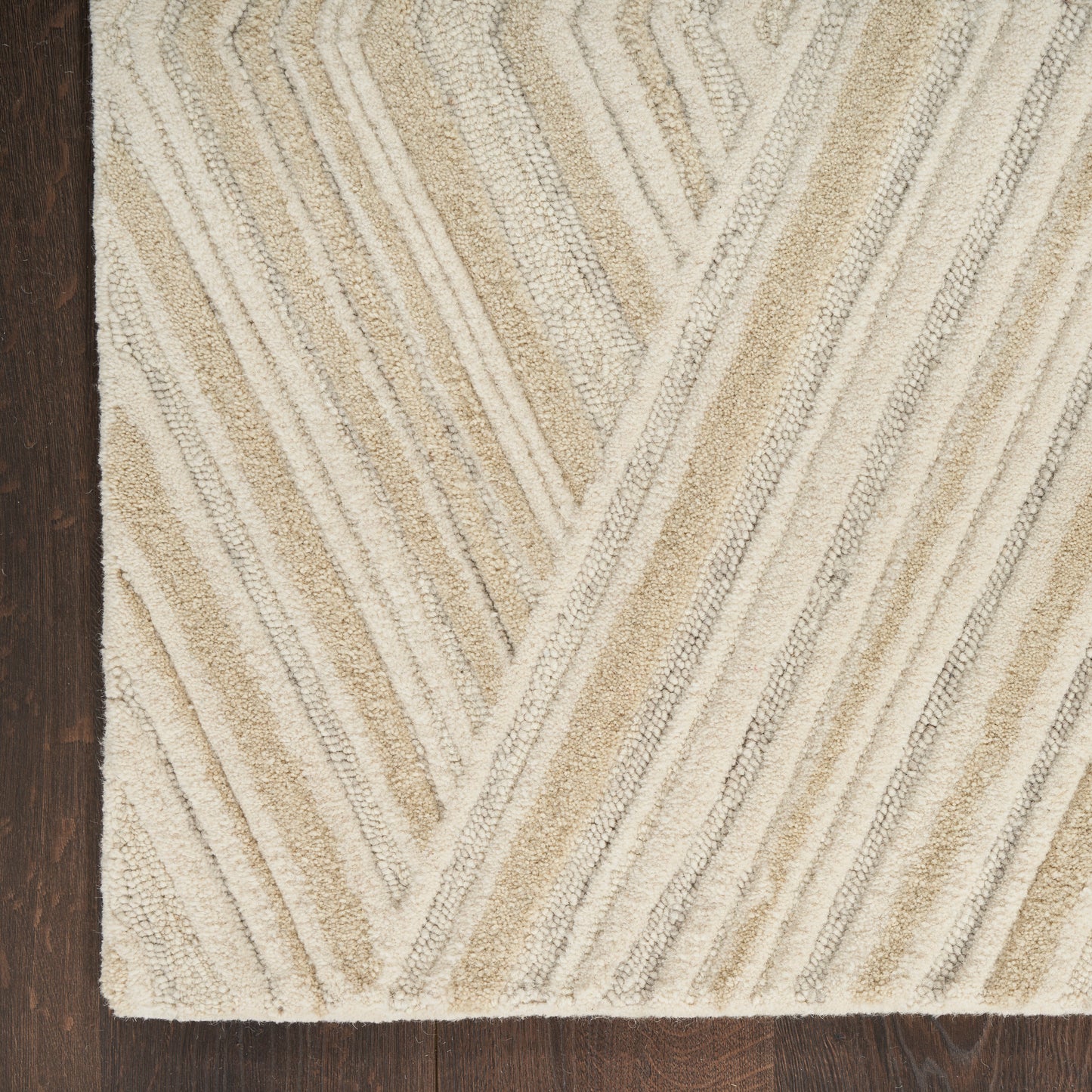 Beige chevron-patterned shag rug with cream and tan stripes on dark wood floor.