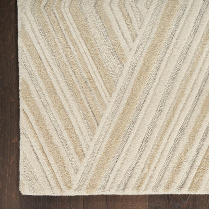 Beige chevron-patterned shag rug with cream and tan stripes on dark wood floor.