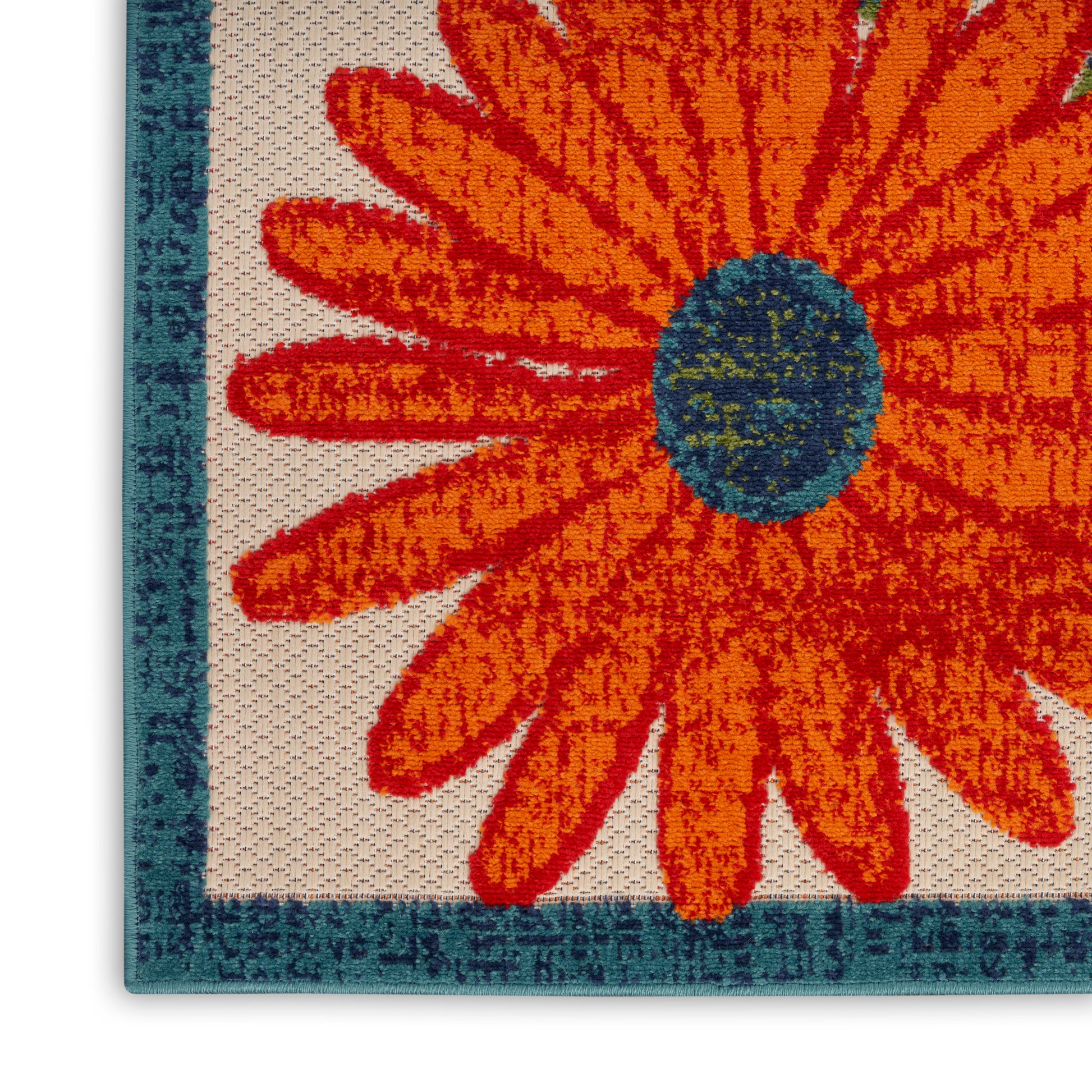 Close-up of outdoor woven runner rug: large orange flower with blue center on beige background and teal border.