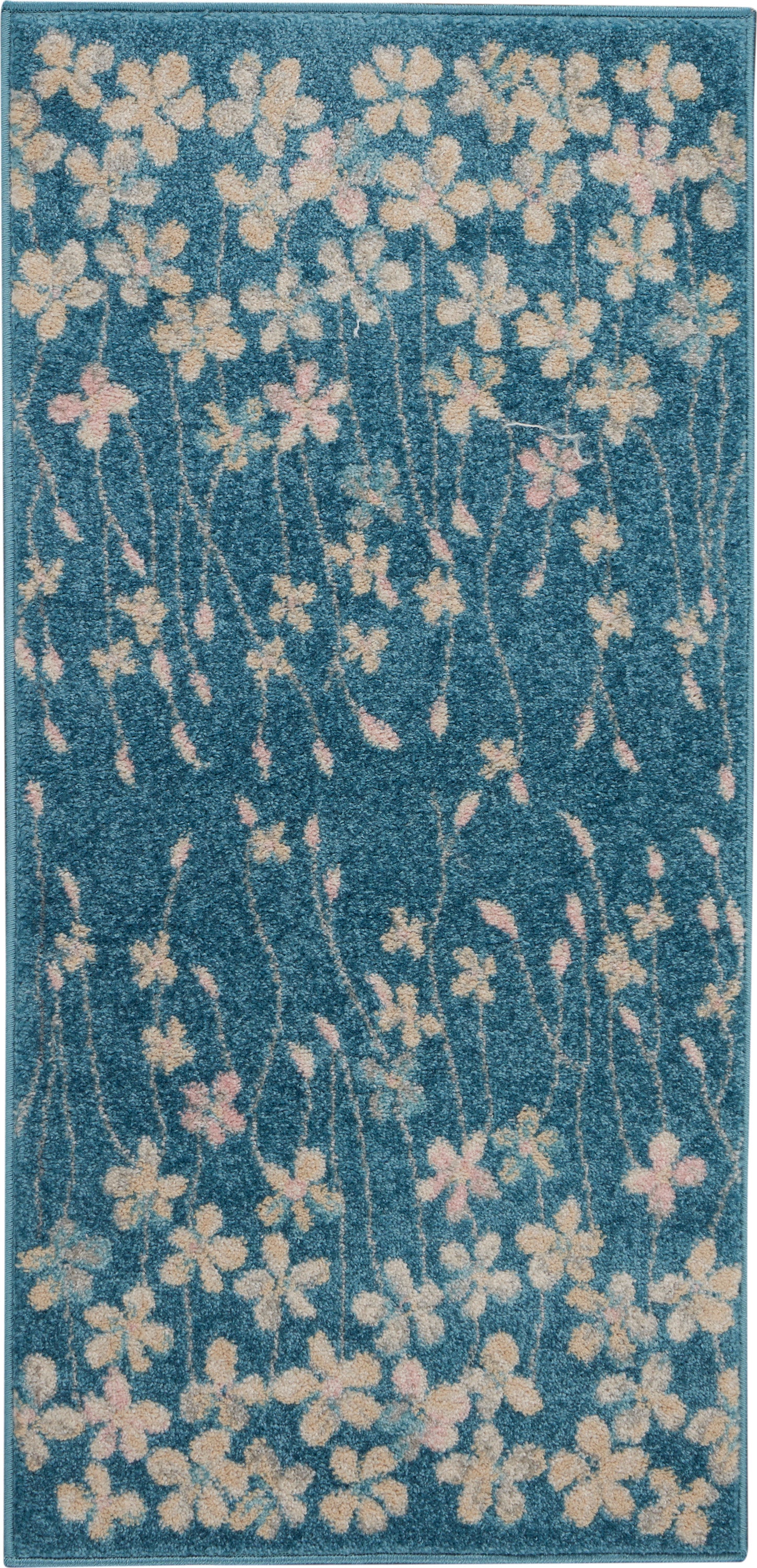 Teal blue floral runner rug with cream and pale pink blossoms on slender stems.