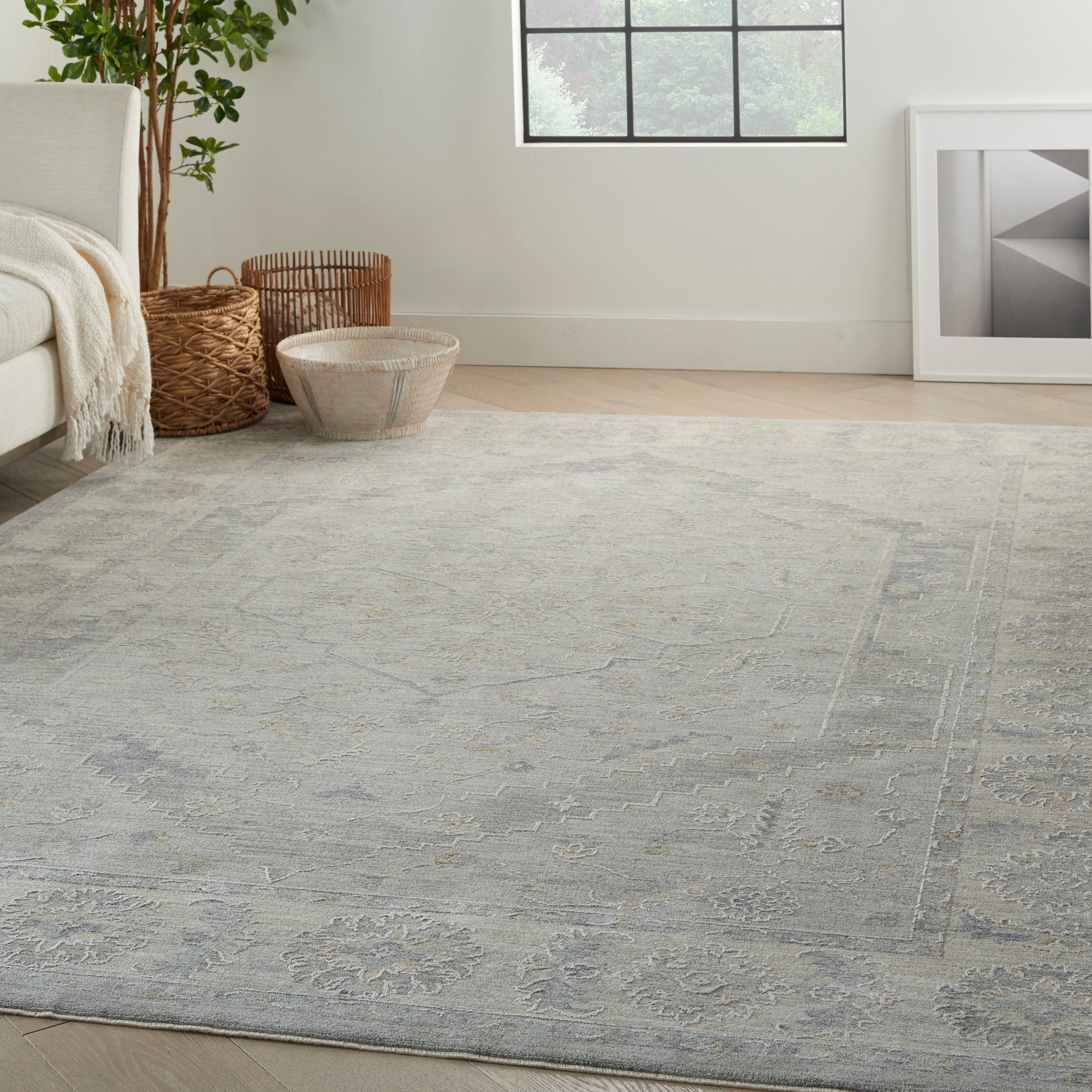 Blue-gray patterned rectangular area rug with subtle floral motifs in a bright living room.