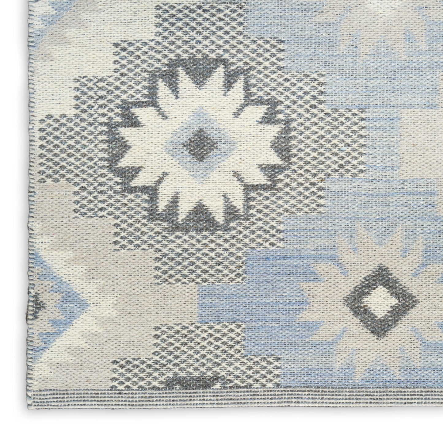 Blue, white & gray woven rug with geometric starburst and diamond motifs; kilim-style textile.