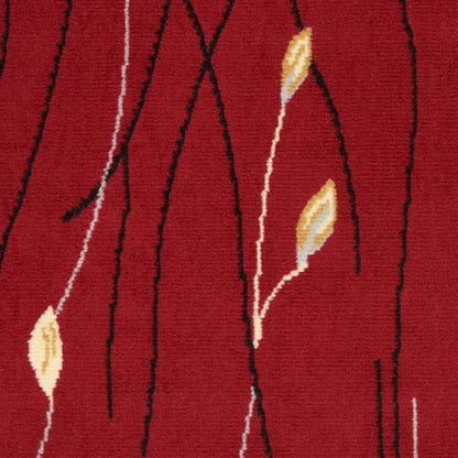 Red tufted rug with black meandering vine lines and beige-yellow leaf accents; modern botanical pattern.