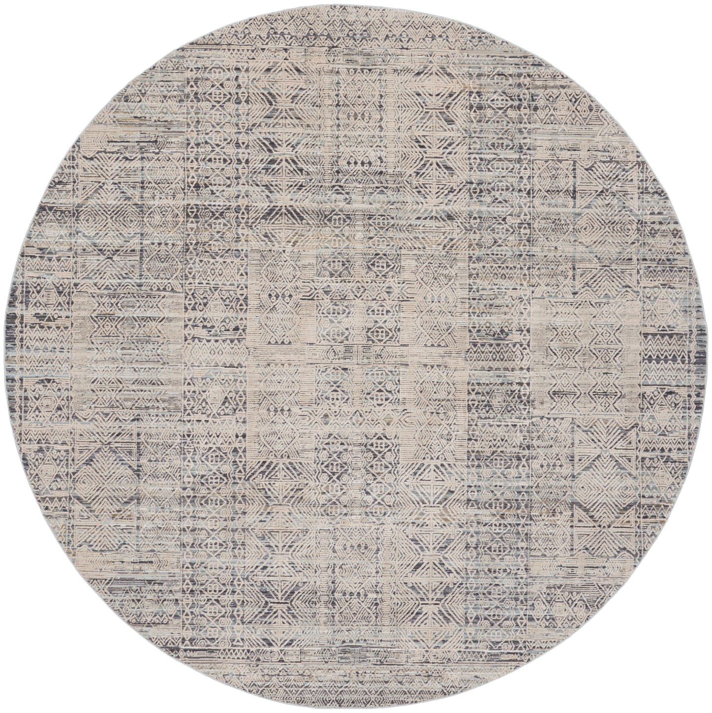 Round woven area rug with distressed beige and navy geometric patchwork.