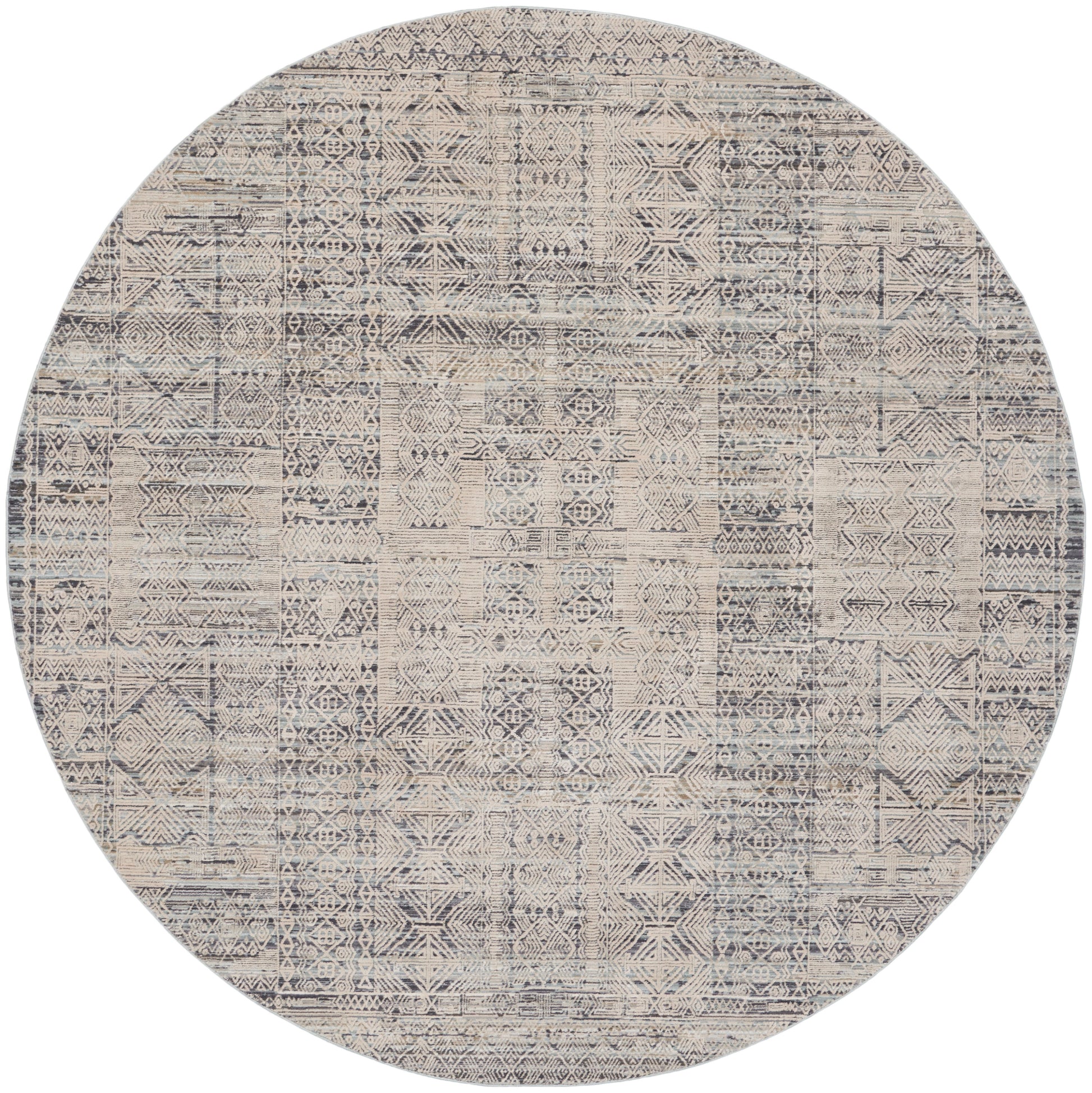 Round woven area rug with distressed beige and navy geometric patchwork.