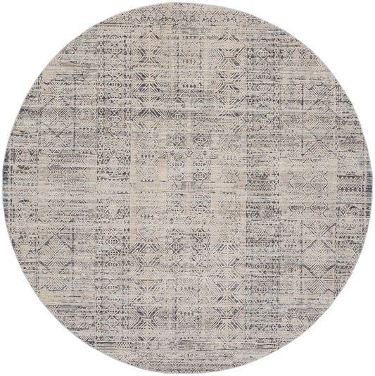 Round woven area rug with distressed beige and navy geometric patchwork.