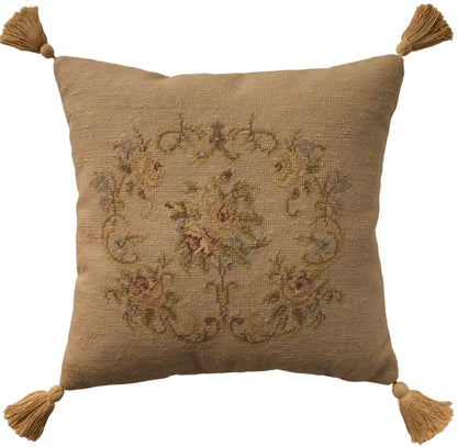 Beige burlap-look square pillow with four corner tassels and a faded vintage floral tapestry design.