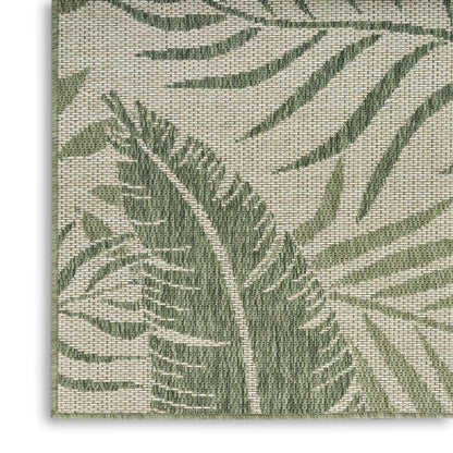 Beige outdoor rug with a woven texture and green tropical palm leaf pattern; natural-fiber look and textured weave.