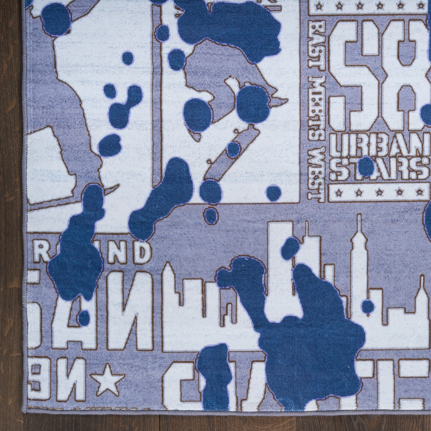 Abstract city skyline area rug in blue, gray and white with splash shapes.