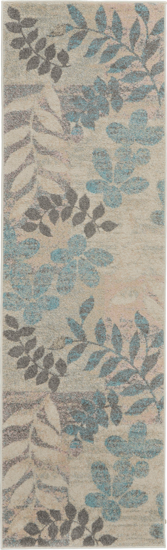 Beige rectangular rug with blue and gray botanical leaf pattern; soft, textured pile for living room decor.