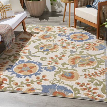 Colorful woven outdoor area rug with beige background and orange, blue, and green florals; suitable for outdoor patios and lounges.
