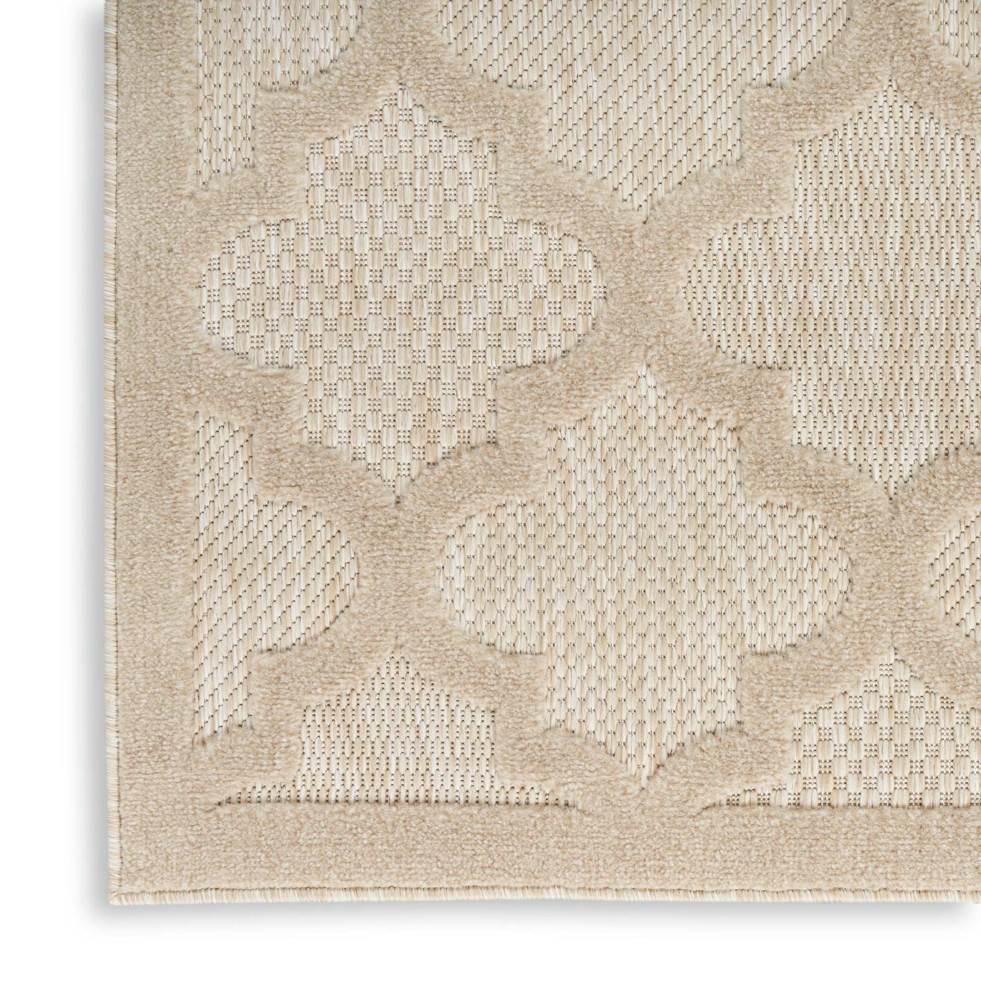 Cream-beige rug with raised quatrefoil lattice pattern and woven texture.