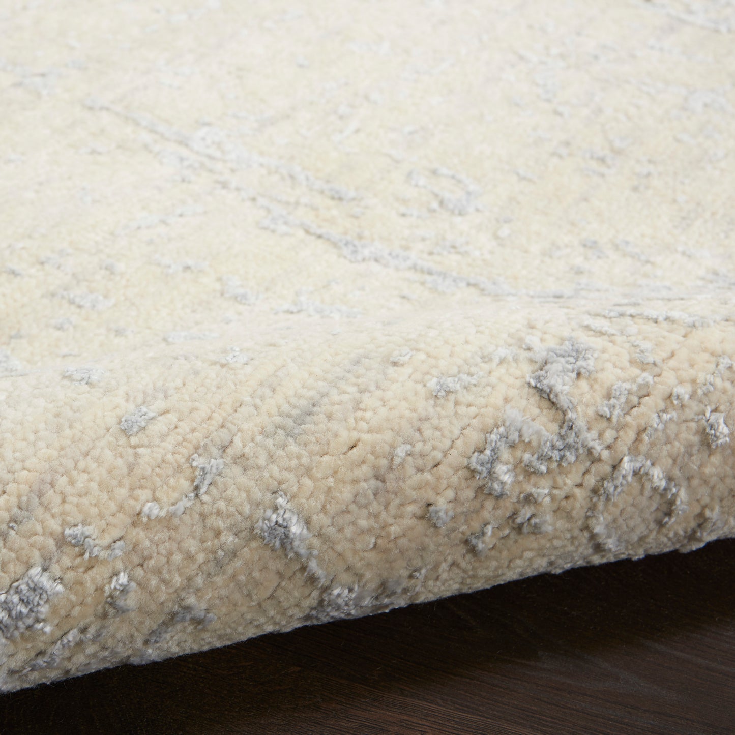 Cream beige rug with subtle gray marbled pattern and plush high-pile texture.