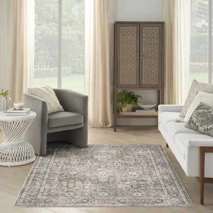 Neutral living room with gray upholstered armchairs, white sofa, woven cabinet, and blue-gray patterned area rug.