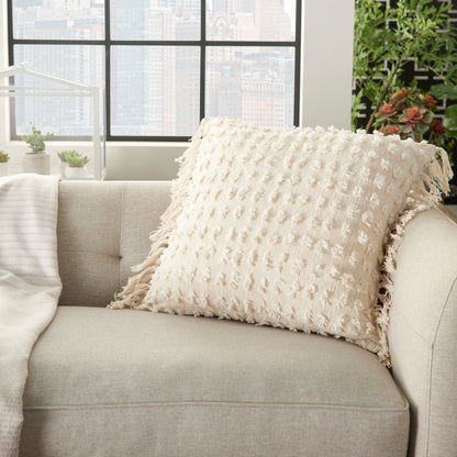 Beige textured throw pillow with fringe on light sofa in bright living room with city views.