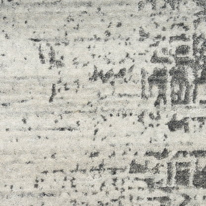 Gray distressed rug with grainy speckle pattern and faded rectangular shapes.