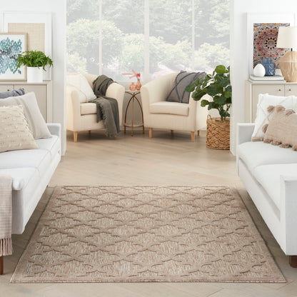 Neutral living room with light beige sofas, woven tan area rug, greenery, and soft throws in a bright, airy space.