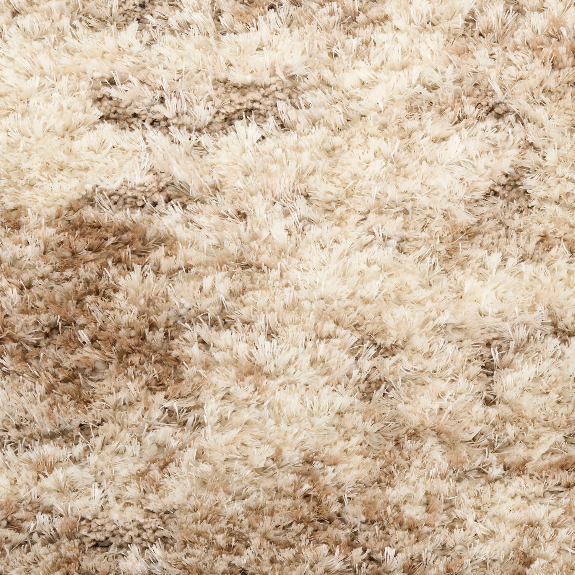 Beige shag rug with long plush fibers and soft high-pile texture for cozy decor.