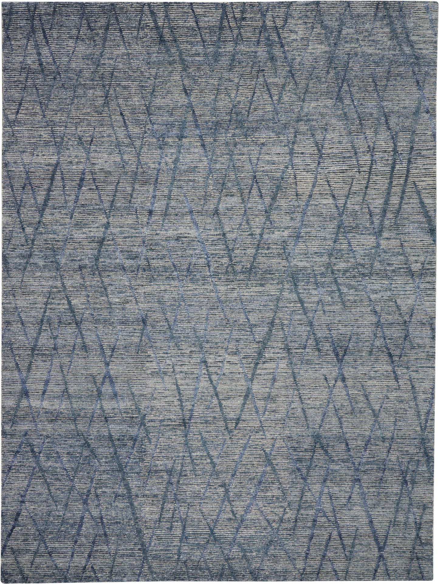 Blue-gray geometric rug with interlocking diamond and zigzag pattern and textured pile.