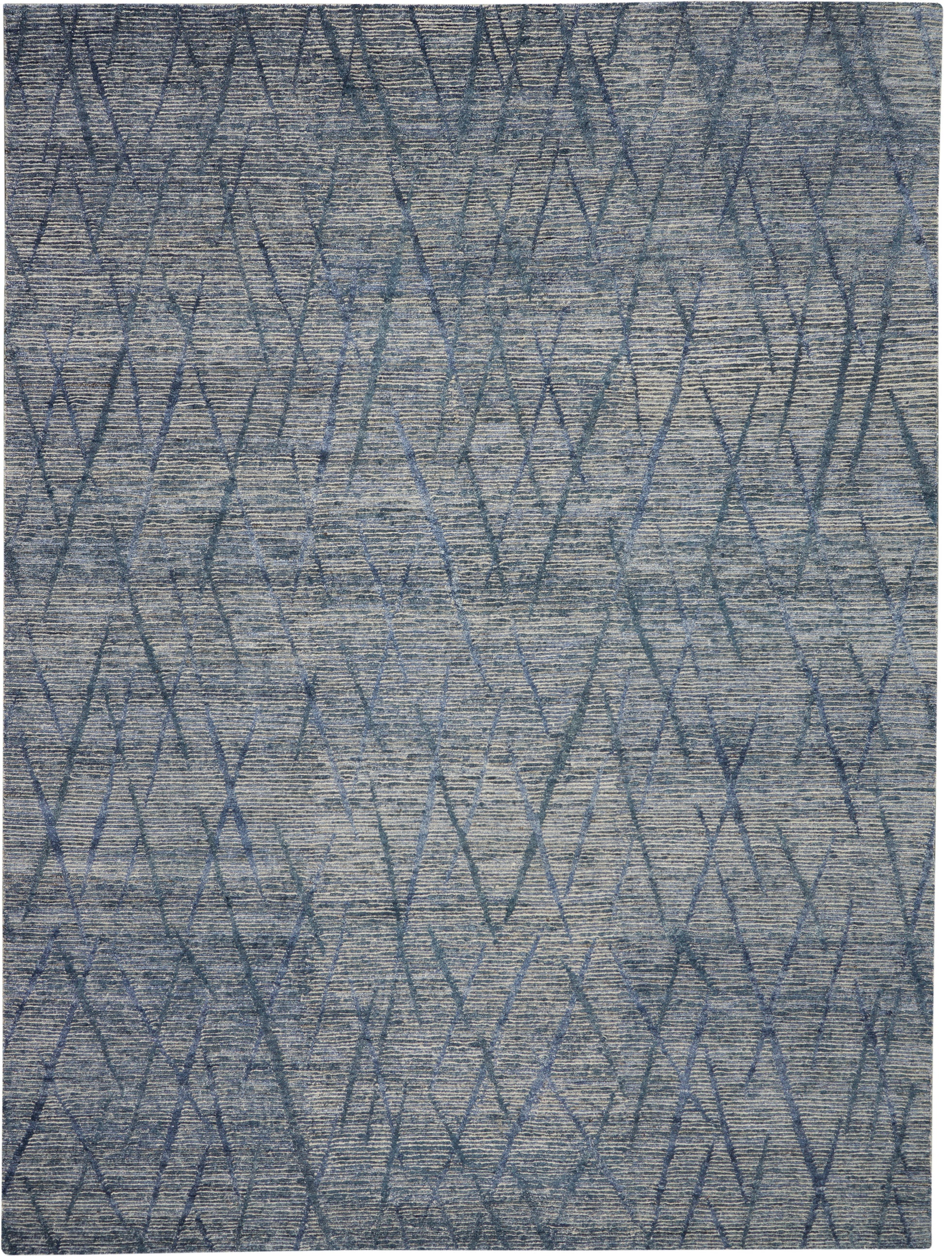 Blue-gray geometric rug with interlocking diamond and zigzag pattern and textured pile.