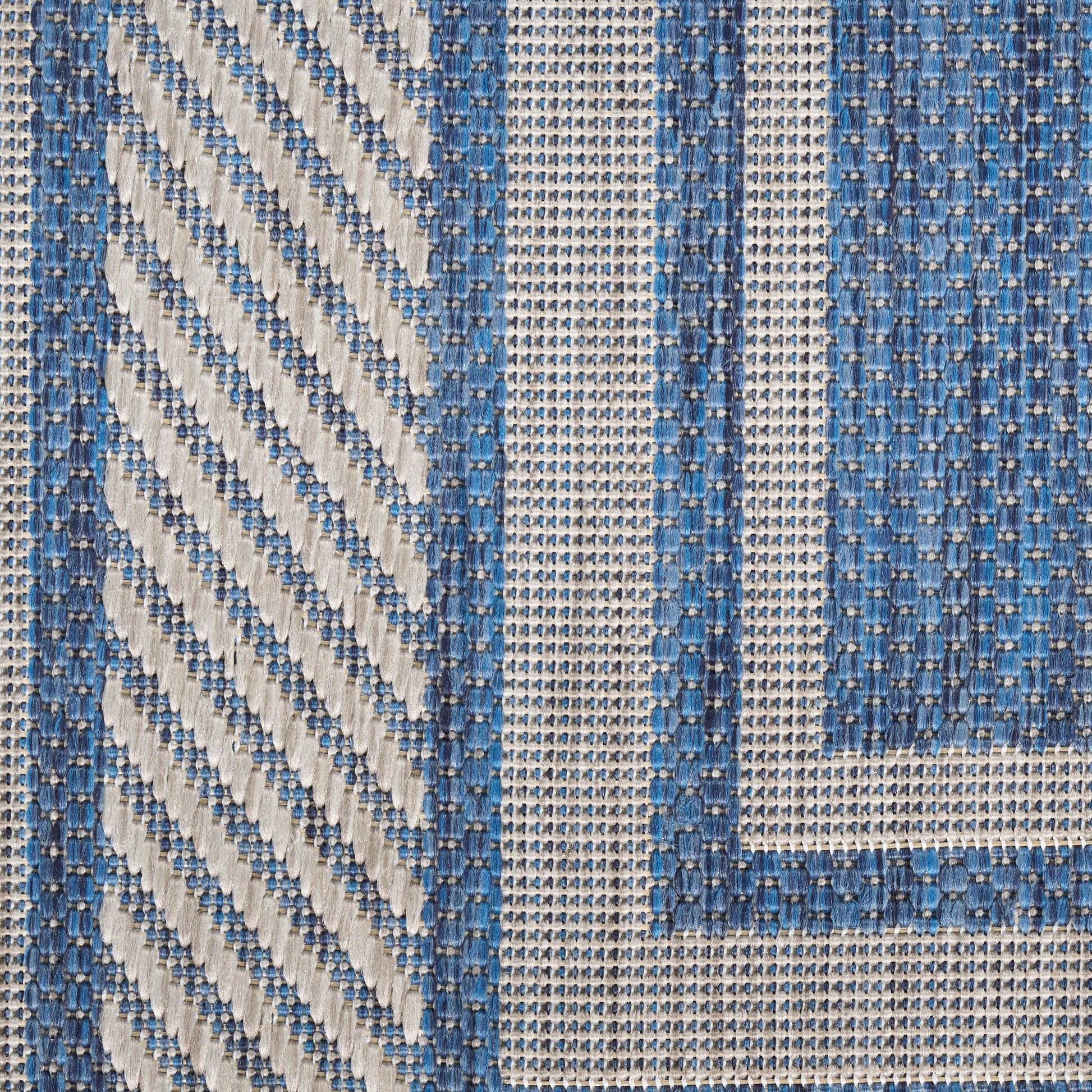Blue and beige woven rug with diagonal stripes and bordered geometric panels in a textured cotton blend.