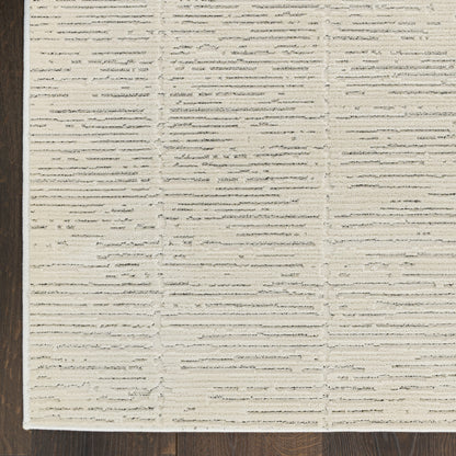 Rectangular beige woven rug with textured horizontal stripe blocks on dark wood floor.