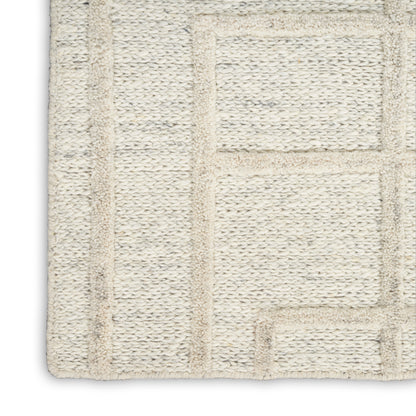 Cream textured rug with raised geometric rectangles, woven loop pile, soft neutral look.