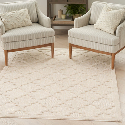 Two cream striped armchairs with wooden legs & beige cushions on a textured neutral area rug in a cozy living room.