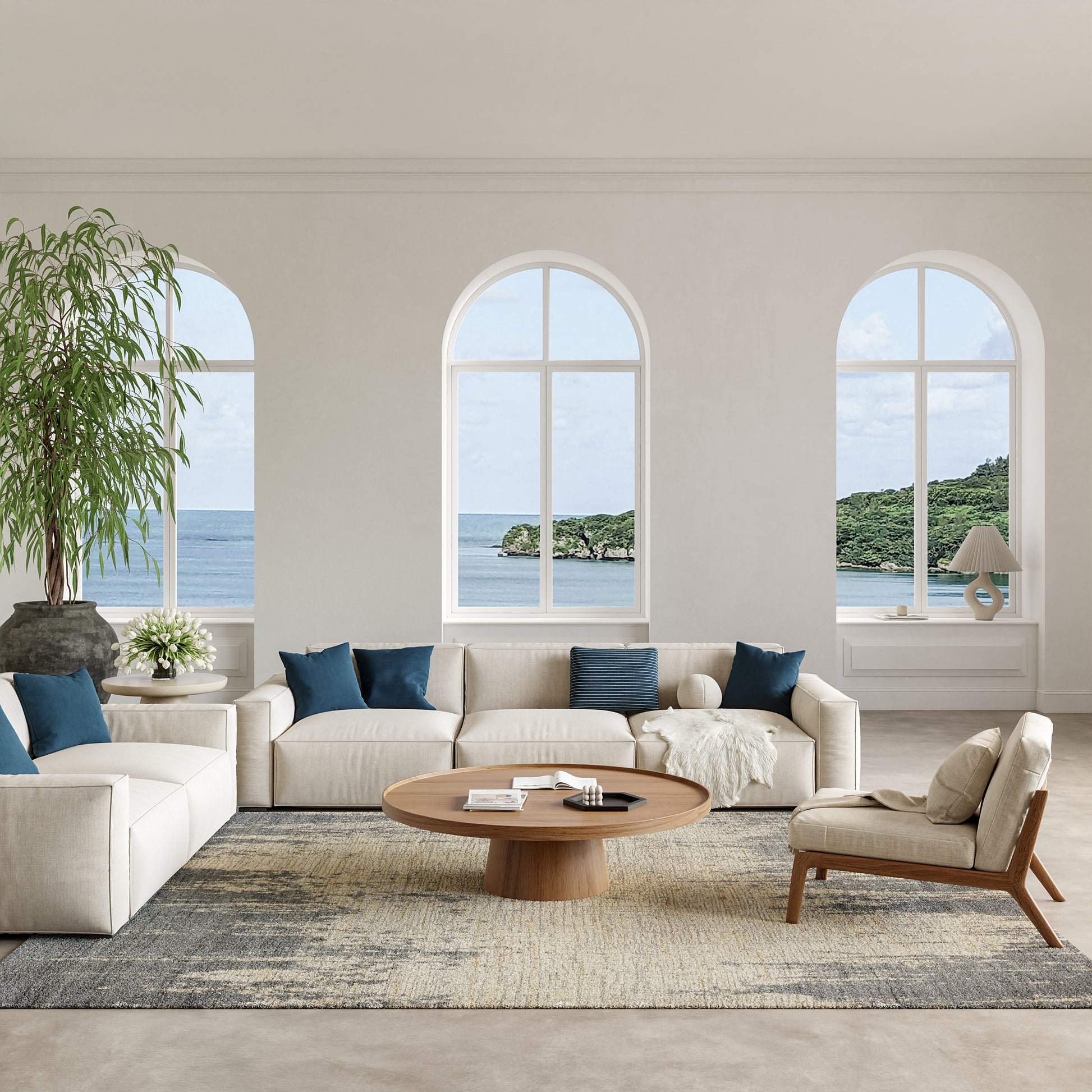 Bright coastal living room featuring a modern rug on the floor; sectional sofa with blue cushions, round wood coffee table, and an armchair.