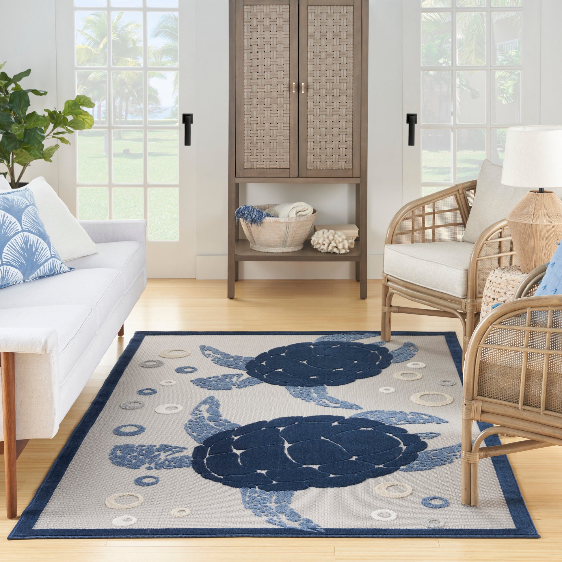 Coastal living room rug featuring large navy sea turtles and circular accents on light beige with a blue border.
