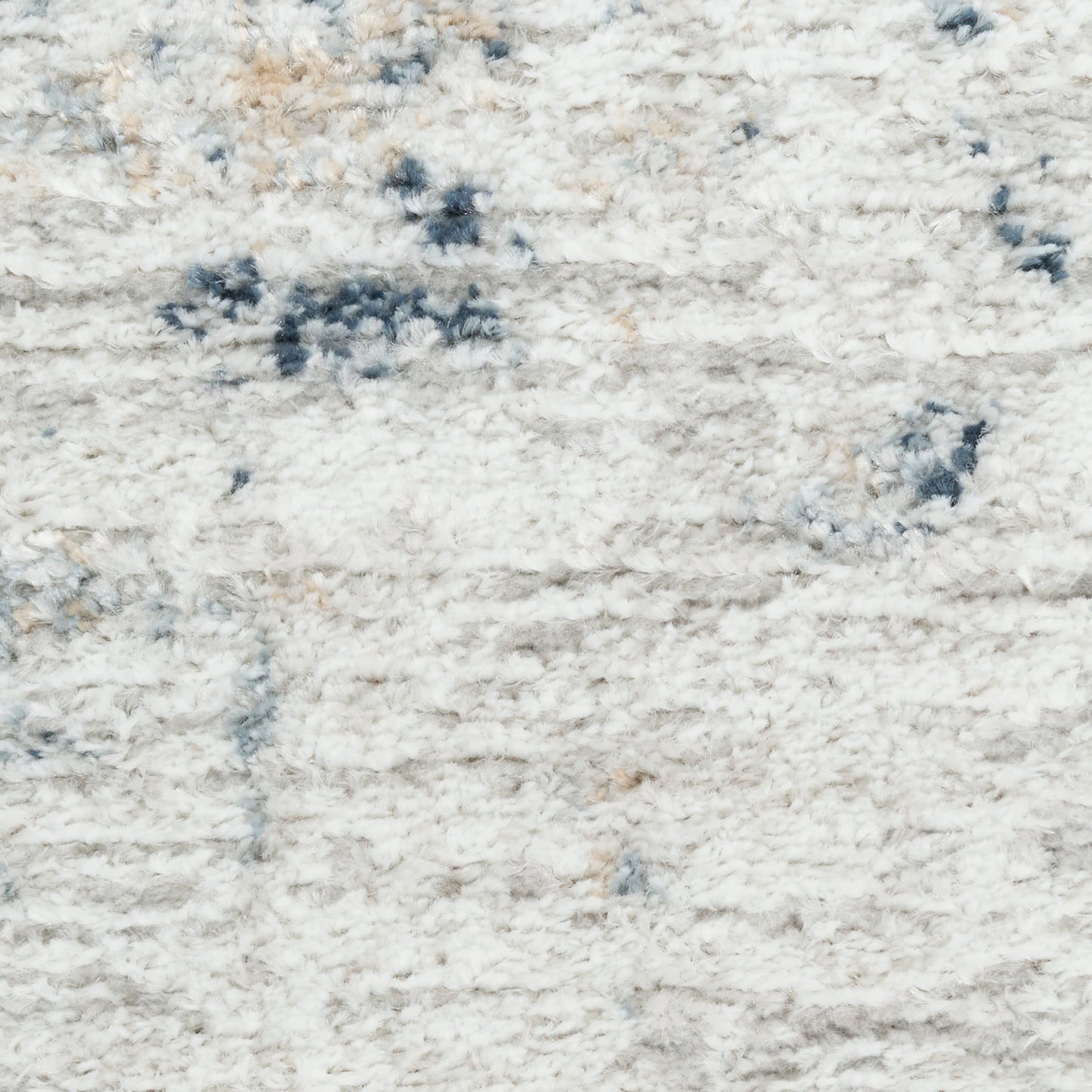 Light gray plush shag rug with cream and blue abstract pattern; soft, thick pile.