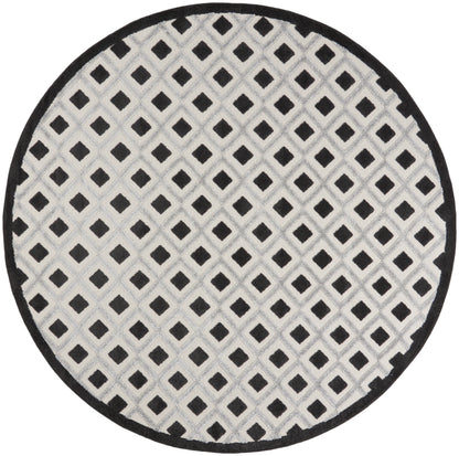 Round rug with light gray field and black diamond lattice pattern, bordered in black.