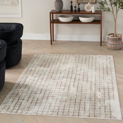 Beige area rug with taupe grid in a modern living room; black sofa edge, wooden console with bowls and candles.
