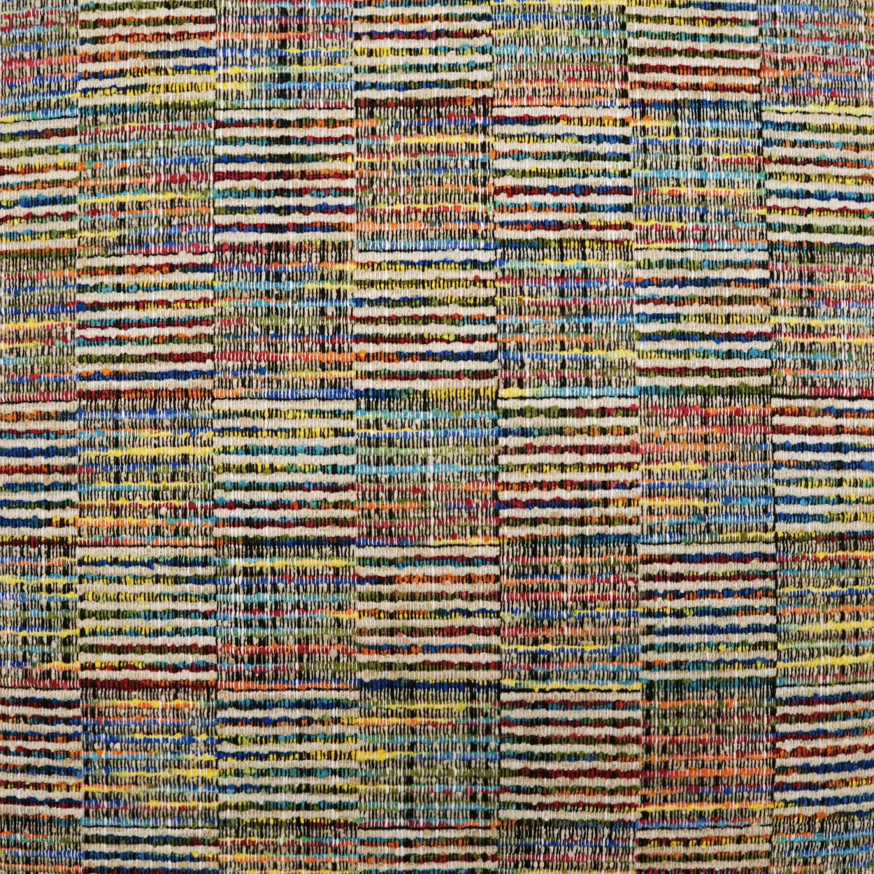 Multicolored woven fabric rug with patchwork plaid blocks in blue, yellow, orange and green; textured yarns.