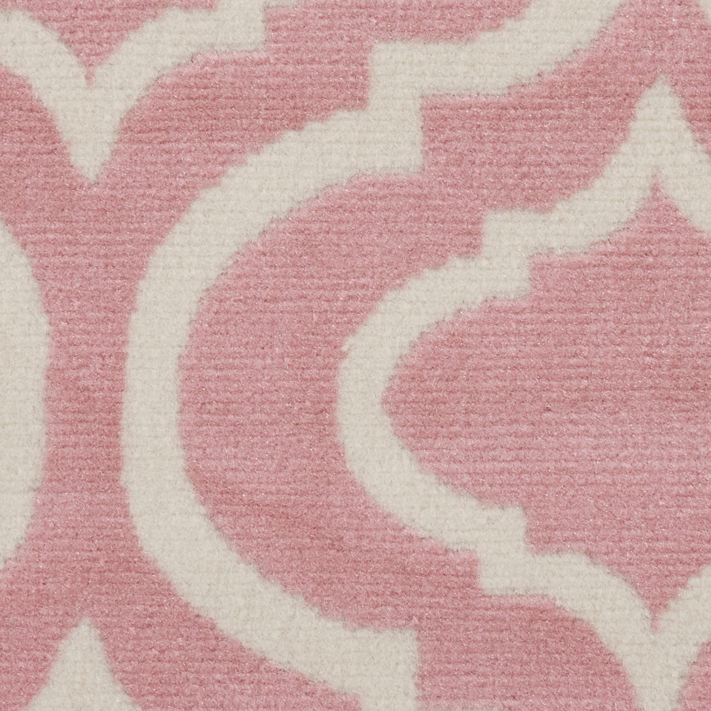 Pink rug with white arabesque pattern in a soft woven texture.