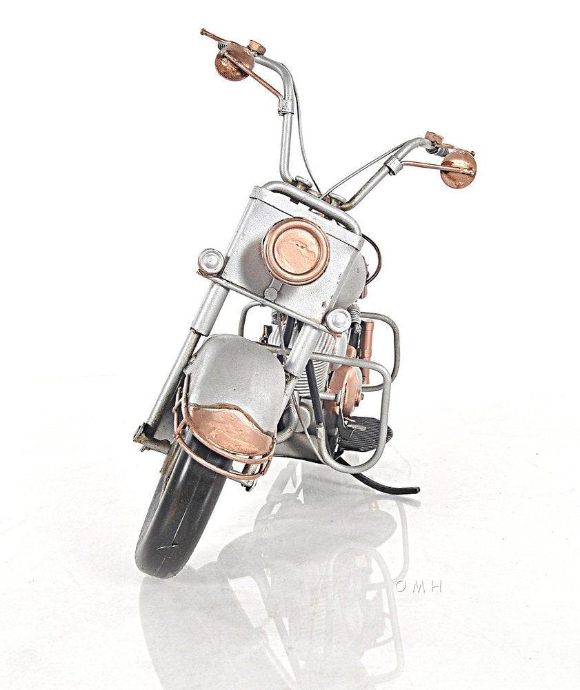 Vintage chrome and copper metal motorcycle sculpture with guard rails and retro round headlight.
