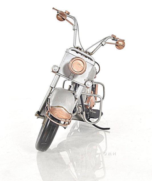 Vintage chrome and copper metal motorcycle sculpture with guard rails and retro round headlight.